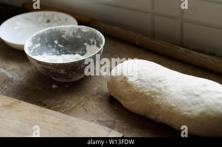 Eine Schüssel Teig auf eine Küche, ein nudelholz. Stockfoto