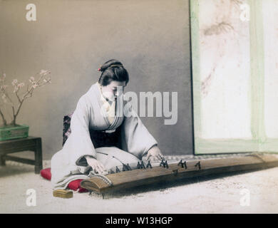 [1890s Japan - Japanische Frau spielen Koto] - eine Frau im Kimono und traditionelle japanische Frisur spielt die Koto, eine Art Harfe. 19 Vintage albumen Foto. Stockfoto