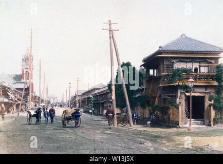 [1890s Japan - Yokohama Street View] - Onoecho-dori (gelegentlich transliteriert als Onouecho-dori), Yokohama, Kanagawa Präfektur. Dies war die Straße zum Bahnhof. Die Station kann schwach im Hintergrund gesehen werden. Die Yokohama Silo Kirche ist auf der linken Seite. Auf der Straße Fußgänger, ein Mann zieht ein jinrikisha und ein Mann Ziehen einer Karre. 19 Vintage albumen Foto. Stockfoto