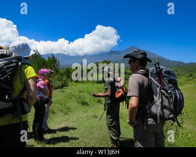 Arusha Nationalpark, Kilimanjaro Provinz/Tansania - 30. Dezember 2015: Ein bewaffneter National Park Ranger beauftragt europäischen Touristen über die Gefahren Stockfoto