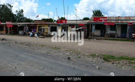 Moshi/Tansania, Kilimanjaro Provinz: 2. Januar 2016: marode Dorf aus Recyclingmaterial, das am Straßenrand in Tansania mit Geschäften und smal Stockfoto