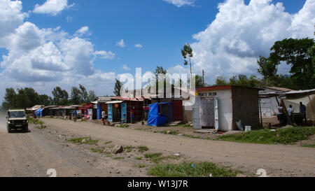 Moshi/Tansania, Kilimanjaro Provinz: 2. Januar 2016: marode Dorf aus Recyclingmaterial, das am Straßenrand in Tansania mit Geschäften und smal Stockfoto