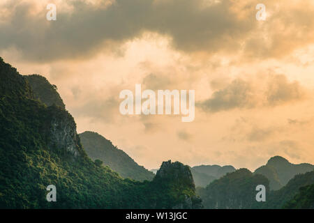 Silhouette der Berge und Inseln im Meer bei Sonnenuntergang. Ha Long Bucht bei Sonnenuntergang. Stockfoto