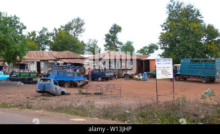 Moshi/Tansania, Kilimanjaro Provinz: 2. Januar, 2016: Garage und Equipment Store im ländlichen Tansania mit beschädigt und alte Fahrzeuge im Cou Stockfoto