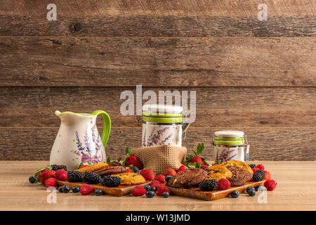 Himbeeren, Waldfrüchten und Schokolade Scones auf hölzernen Platte Stockfoto
