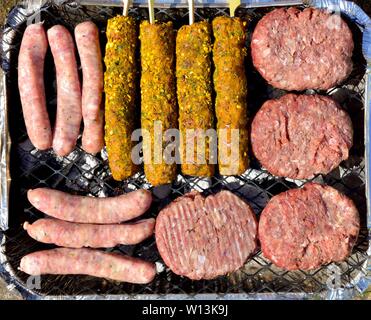 Verfügbare Instant BBQ Folie Fach, mit rohem, beefburgers, Würstchen, Kebabs Stockfoto