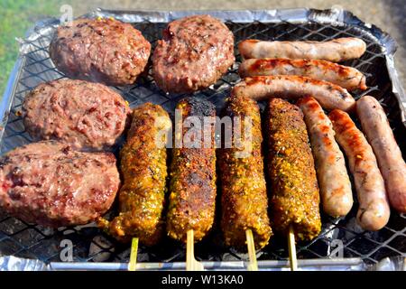 Verfügbare Instant BBQ Folie Fach kochen, beefburgers, Würstchen, und Kebabs Stockfoto