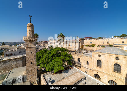 Alte Minarett unter typischen Häuser unter blauem Himmel in der Altstadt von Jerusalem, Israel (Ansicht von oben). Stockfoto