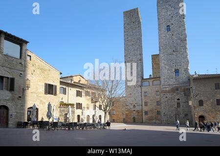San Gimignano, Italien - 03. März 2019: Touristen, die in der kleinen und charakteristischen Mittelalterlichen Stadt in der Toskana in der Nähe von Siena Stockfoto