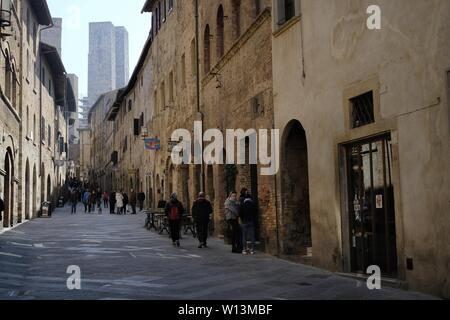 San Gimignano, Italien - 03. März 2019: Touristen, die in der kleinen und charakteristischen Mittelalterlichen Stadt in der Toskana in der Nähe von Siena Stockfoto