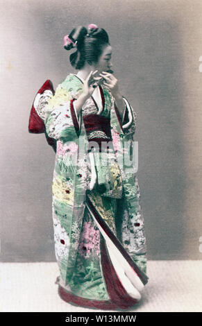 [1890s Japan - Maiko Spielen der Querflöte] - die Geisha im Kimono und traditionelle Frisur spielt die Flöte. 19 Vintage albumen Foto. Stockfoto