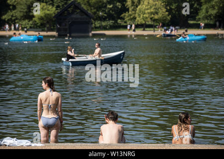 Touristen genießen den Sonnenschein in der Serpentine im Hyde Park, London. Eine der britischen aalt sich in 33 C Sonnenschein während der heißesten Tag des Jahres, den 29. Juni 2019 Stockfoto