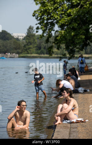 Touristen genießen den Sonnenschein in der Serpentine im Hyde Park, London. Eine der britischen aalt sich in 33 C Sonnenschein während der heißesten Tag des Jahres, den 29. Juni 2019 Stockfoto