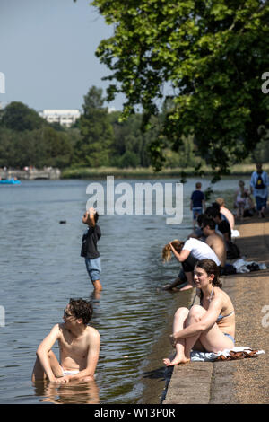 Touristen genießen den Sonnenschein in der Serpentine im Hyde Park, London. Eine der britischen aalt sich in 33 C Sonnenschein während der heißesten Tag des Jahres, den 29. Juni 2019 Stockfoto