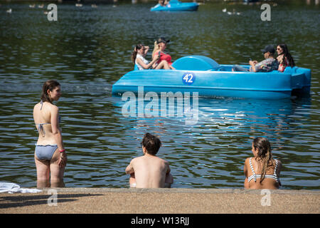 Touristen genießen den Sonnenschein in der Serpentine im Hyde Park, London. Eine der britischen aalt sich in 33 C Sonnenschein während der heißesten Tag des Jahres, den 29. Juni 2019 Stockfoto