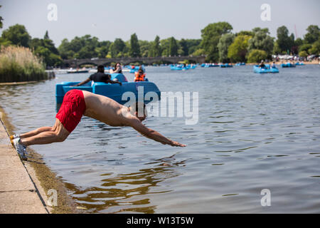 Touristen genießen den Sonnenschein in der Serpentine im Hyde Park, London. Eine der britischen aalt sich in 33 C Sonnenschein während der heißesten Tag des Jahres, den 29. Juni 2019 Stockfoto