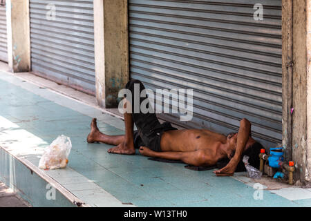 Bangkok, Thailand - 13 April, 2019: Obdachlosen Mann liegen und schlafen auf der Straße in Bangkok. Stockfoto