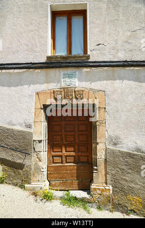 Tür mit steinernen Türsturz mit Wappen des XIX Jahrhunderts Gebäude, das Rathaus und die Schule in Gistaín (Chistau, Huesca, Aragón, Spanien) untergebracht Stockfoto