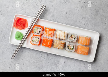 Japanisches Sushi. Sashimi, maki Rollen. Auf der Platte über Stein Hintergrund Stockfoto