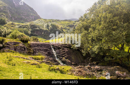 Picturesgue Tal in den Gleninchaquin Park mit kleinen Bach fließen auf Fels. County Kerry, Irland. Stockfoto