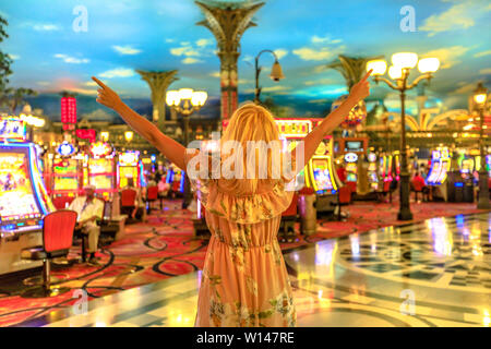 Glückliche Gewinner kaukasische Frau im Casino von Las Vegas, Nevada, USA. Blonde Dame genießen, Geld und Glück genug, um zu gewinnen. Architektur Stockfoto