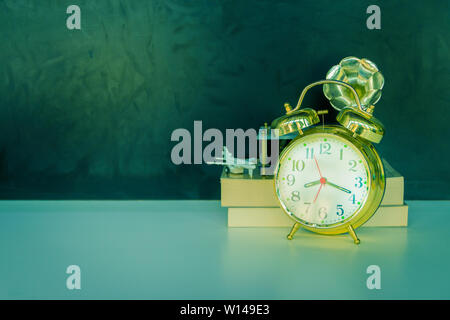 Wecker alte Vintage gold- und Buch-Ebene Kunststoff. in Weiß auf schwarzem Hintergrund. Mit copy space Text hinzufügen. Farbe filmische Vintage Style Ton. C Stockfoto