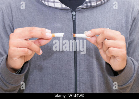 Männliche junge Holding zerbrochene Zigarette in der Hand. health care Konzept, das Rauchen aufzugeben. Stockfoto