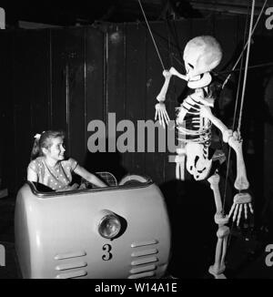 Amusement Park in den 1950er Jahren. Ein junges Mädchen ist, die unheimlich Fahrt von sich und übergibt einen Skelett während der Fahrt. Schweden 31. Mai 1958, Ref 3760 Stockfoto