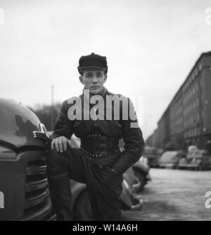 Der Motorradfahrer in den 1950er Jahren. Ein junger Mann, der in der typischen Art und Weise der Motorradfahrer in den 1950er Jahren tat gekleidet. Alle Leder. Leder Stiefel, Hose und Jacke. Einen nierengurt und ein typisches Motorradfahrer cap. Schweden Dezember 1954 Stockfoto