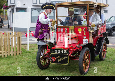 Datchet, UK. 30 Juni, 2019. Chris Brown, offizielle Stadtausrufer des Royal Borough of Windsor und Maidenhead, begrüßt den Fahrer eines 1904 De Dion Bouton, der erste von vielen pre-1905 Fahrzeuge auf dem 48-Meile Ellis Reise von Micheldever Station in der Nähe von Winchester zu Datchet, eine Wiederinkraftsetzung der ersten aufgezeichneten Reise durch eine motorisierte Kutsche in England von Pioneer automobilist Hon. Evelyn Ellis in seinem neuen, benutzerdefinierten durchgeführt - Integrierte panhard-levassor am 5. Juli 1895 zu kommen. Credit: Mark Kerrison/Alamy leben Nachrichten Stockfoto