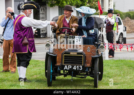 Datchet, UK. 30 Juni, 2019. Chris Brown, offizielle Stadtausrufer des Royal Borough of Windsor und Maidenhead, begrüßt die Insassen von 1904 Humberette wie es der 48-mile Ellis Reise führt von Micheldever Station in der Nähe von Winchester in Datchet. Die Ellis Reise ist eine Nachstellung der ersten aufgezeichneten Reise durch eine motorisierte Kutsche in England von Pioneer automobilist Hon. Evelyn Ellis in seinem neuen, benutzerdefinierten durchgeführt - Integrierte panhard-levassor am 5. Juli 1895. Die ursprüngliche Reise fand unter Verstoß gegen das Gesetz, weil die Panhard eine Geschwindigkeit von 4 km/h überschritten und wurde nicht durch eine Telefonzentrale voraus Stockfoto