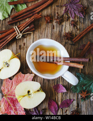 Heißes Getränk (Apple Tee, sider, Punch) mit Zimtstange, Sternanis und Nelke. Saisonale Glühwein trinken auf Holz- Hintergrund. Heißes Getränk und Äpfel für eine Stockfoto