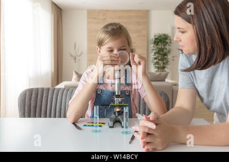 Mutter und Tochter dabei einige Experimente mit Mikroskop zu Hause Stockfoto