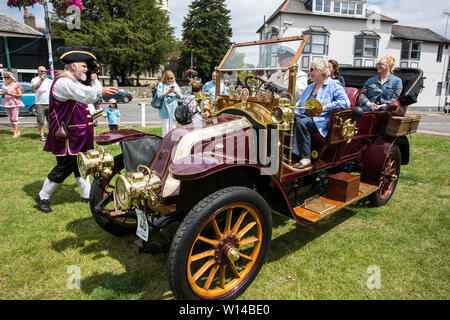 Datchet, UK. 30 Juni, 2019. Chris Brown, offizielle Stadtausrufer des Royal Borough of Windsor und Maidenhead, begrüßt die zweite der pre-1905 teilnehmenden Fahrzeugen in der 48-Meilen-Zone Ellis Reise von Micheldever Station in der Nähe von Winchester zu Datchet zu gelangen. Die Ellis Reise ist eine Nachstellung der ersten aufgezeichneten Reise durch eine motorisierte Kutsche in England von Pioneer automobilist Hon. Evelyn Ellis in seinem neuen, benutzerdefinierten durchgeführt - Integrierte panhard-levassor am 5. Juli 1895. Die ursprüngliche Reise fand unter Verstoß gegen das Gesetz, weil die Panhard eine Geschwindigkeit von 4 km/h überschritten und wurde nicht vorangestellt Stockfoto