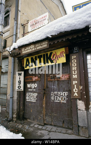 Am 28. März 1993 während der Belagerung von Sarajevo: nach einer Sicherheitsabschaltung Antiquitätenladen bei 93 Marsala Tita Straße in die baščaršija. Auf einer Giebelwand oben Es ist die typische Narbe von einem direkten Treffer aus einem Mörser oder Artillerie Shell. Stockfoto