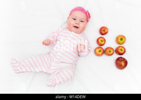 Süße kleine Baby Mädchen mit auf weißem Hintergrund mit frischen Rot-grüne Äpfel in Form von Nummer vier Stockfoto