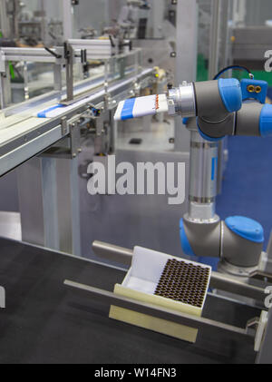 Automation Roboterarm last Aluminium Rohr zu Abfüllmaschine in der Produktionslinie Stockfoto