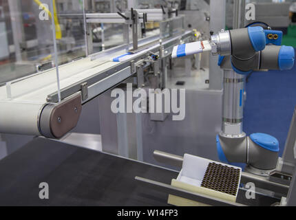 Automation Roboterarm last Aluminium Rohr zu Abfüllmaschine in der Produktionslinie Stockfoto