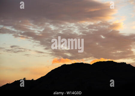 Wolken bei Sonnenuntergang über Loughrigg, Ambleside, Lake District, England. Stockfoto