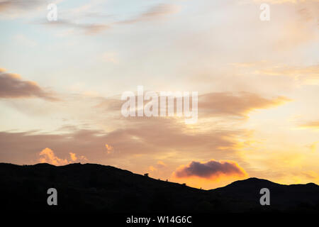 Wolken bei Sonnenuntergang über Loughrigg, Ambleside, Lake District, England. Stockfoto