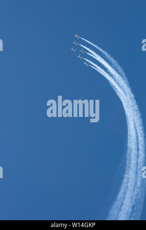 Kunstflugvorführung der "Patrouille de France" mit alpha-jets am tiefblauen Himmel, weisse Kondensstreifen in einer weiten Kurve aufwärts Stockfoto