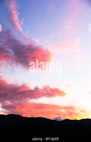 Wolken bei Sonnenuntergang über Loughrigg, Ambleside, Lake District, England. Stockfoto