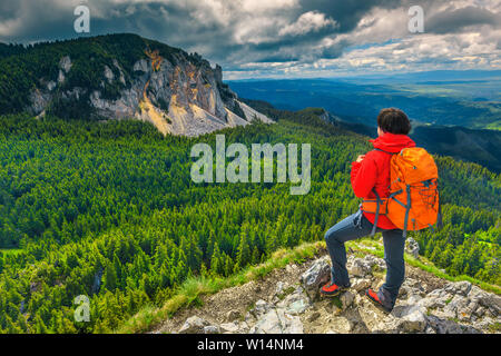 Fröhliche Wanderer Frau mit Rucksack, genießen den Blick in die Berge. Sportliche backpacker Wanderer auf den Klippen, Hasmasul Mare Berg Gruppe, Karpaten, Stockfoto