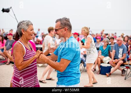 Ein älteres Paar tanzt bei einem Festival am Pensacola Beach, Florida, unter der Menge Stockfoto