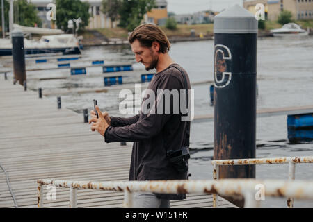 Stilvolle hipster Fotograf in einer großen Stadt mit einer Kamera und einem Rucksack auf dem Rücken. Stockfoto