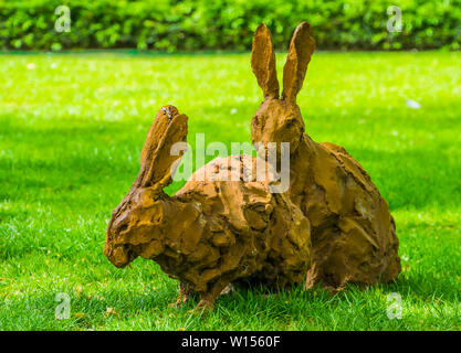 Zwei braune Osterhase Statuen in einem Rasen, Dekorationen für den Urlaub oder den Garten Stockfoto