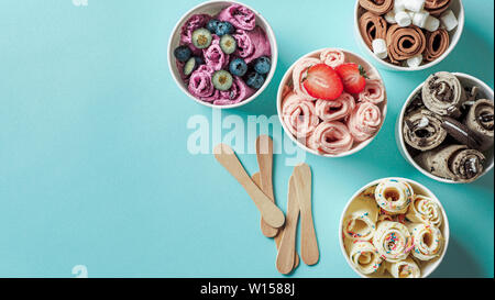 Gerollt Eis cone Cups auf blauem Hintergrund. Verschiedene iced Brötchen Top View oder flach. Im thailändischen Stil gerollt Eis mit Kopie Platz für Text oder Design. Banner Stockfoto
