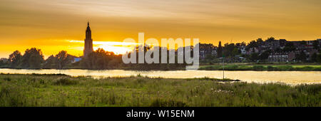 Skyline der Stadt Rhenen bei Sonnenuntergang mit cunera Kirche und Fluss Nederrrijn in der Provence von Utrecht in den Niederlanden Stockfoto