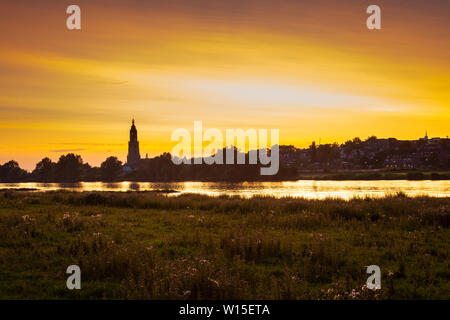 Skyline der Stadt Rhenen bei Sonnenuntergang mit cunera Kirche und Fluss Nederrrijn in der Provence von Utrecht in den Niederlanden Stockfoto