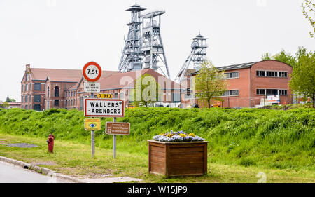 Die ehemalige Arenberg Mine in Wallers im Bergbau Becken des Nord-Pas-de-Calais, Frankreich, mit dem Ortsschild im Vordergrund. Stockfoto